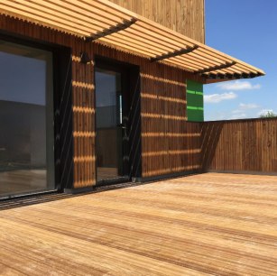 Terrasse en bois devant un bâtiment moderne avec façade en bois